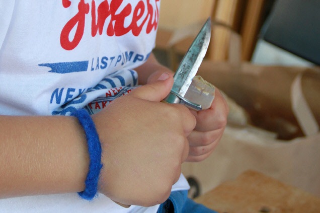 Barnhänder täljer med en kniv
