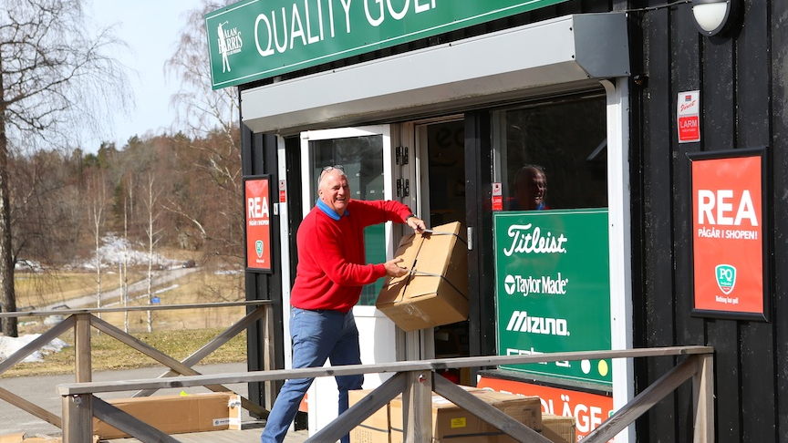 En man står och lastar in kartonger i en affär