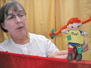 En kvinna glasögon som håller i en docka av Pippi Långstrump.