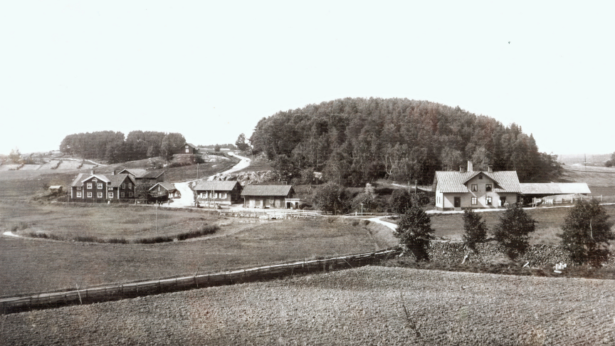 En svartvit bild med hus och åkrar