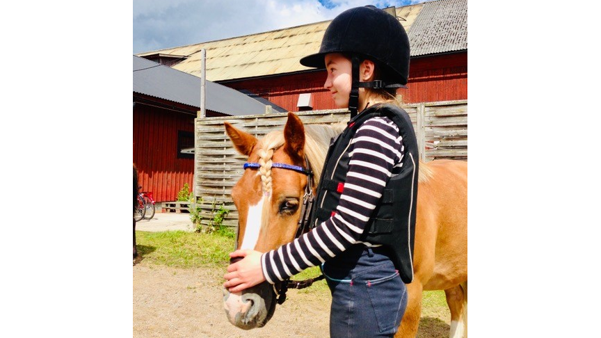 En flicka som håller i en häst