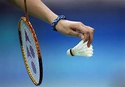 hand som håller i badmintonboll och ett badmintonrack