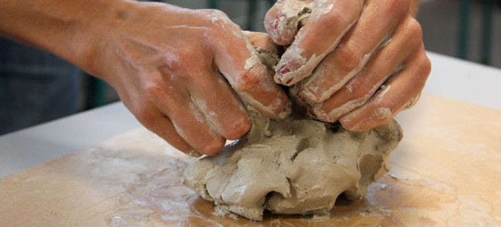 Händer knådar en lerklump