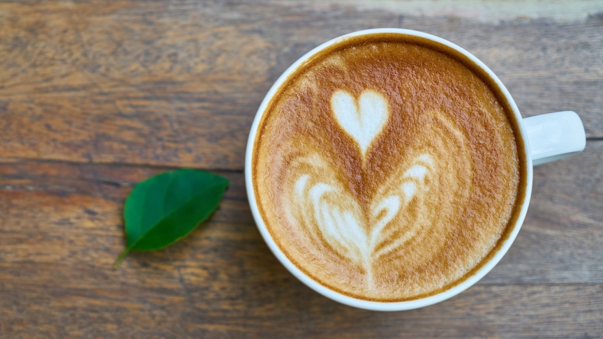 En kopp kaffe med ett hjärta gjort av mjölkskum.