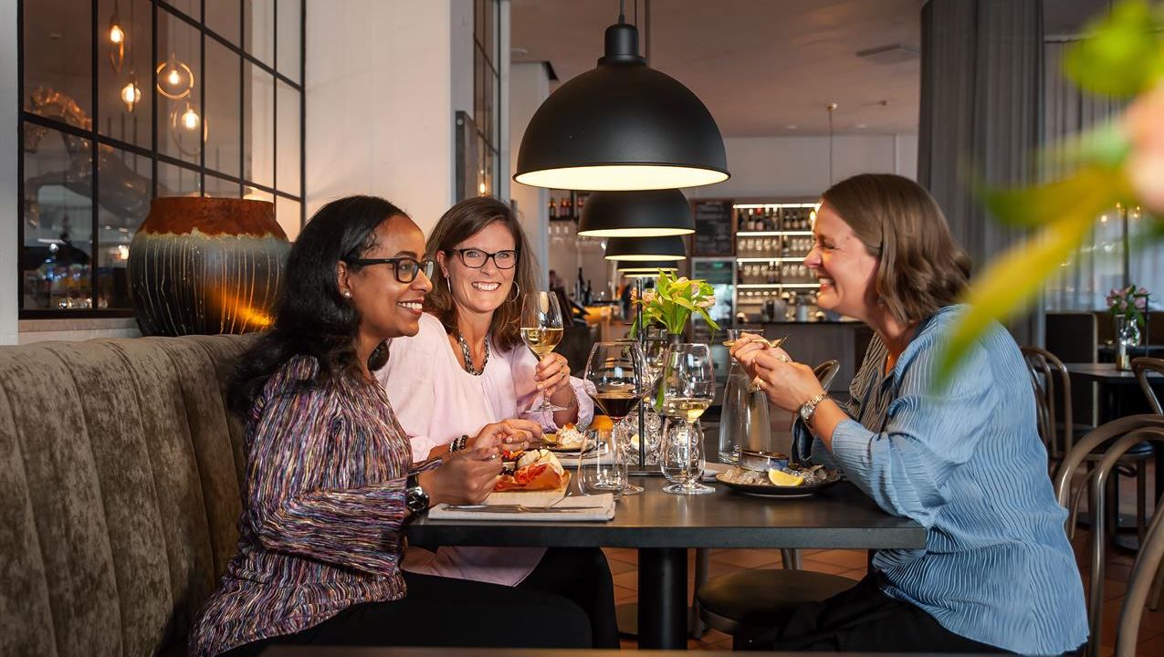 Tre kvinnor som äter middag tillsammans