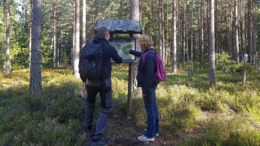 Två personer som står och kollar på en skylt